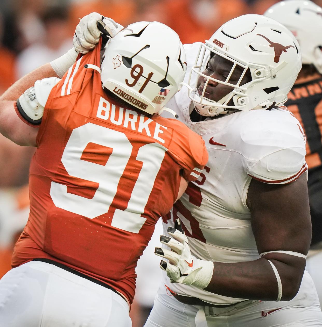 Texas offensive lineman Cameron Williams, right, grabs the uniform of edge rusher Ethan Burke during the second quarter of Saturday's Orange-White spring game at Royal-Memorial Stadium. Texas' defensive line is in a rebuilding mode with the loss of soon-to-be-NFL players T'Vondre Sweat and Byron Murphy II.