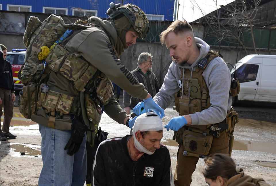 Medics apply first aid to a man at the site of a Russian attack in Kharkiv, Ukraine, Wednesday, March 20, 2024. (AP Photo/Efrem Lukatsky)