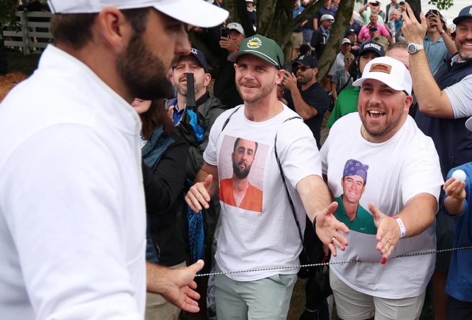Scottie Scheffler, left, shakes hands with fans wearing Scottie Scheffler T-shirts as he walks off the ninth green during the second round of the PGA Championship at Valhalla Golf Club on Friday in Louisville.