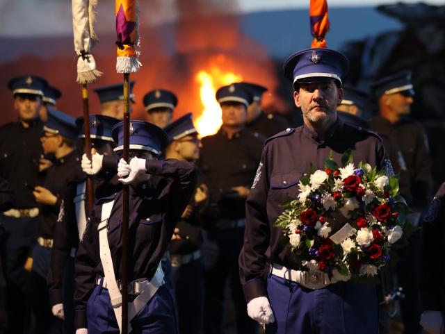 The Cairncastle Flute Band leader with a wreath before laying it during the vigil (Liam McBurney/PA) (PA Wire)