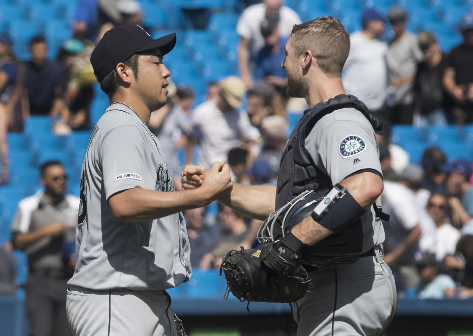 Seattle Mariners starting pitcher Yusei Kikuchi shakes hands with catcher Tom Murphy after pitching a complete game shutout against the Toronto Blue Jays in a baseball game in Toronto, Sunday, Aug. 18, 2019. (Fred Thornhill/The Canadian Press via AP)