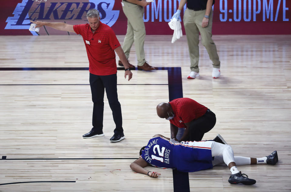 Brett Brown watches as Tobias Harris, on the floor, is attended to after a scary fall. 