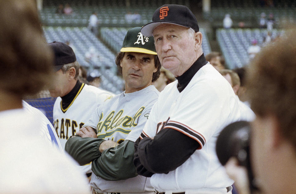FILE - American League manager Tony La Russa, center left, from the Oakland A's, and National League manager Roger Craig, of the San Francisco Giants, watch batting practice at Wrigley Field in Chicago, July 10, 1990, before the start of the 61st All-Star Game. Craig, who pitched for three championship teams during his major league career and then managed the San Francisco Giants to the 1989 World Series that was interrupted by a massive earthquake, died Sunday, June 4, 2023. He was 93. (AP Photo/Rob Kozloff, File)
