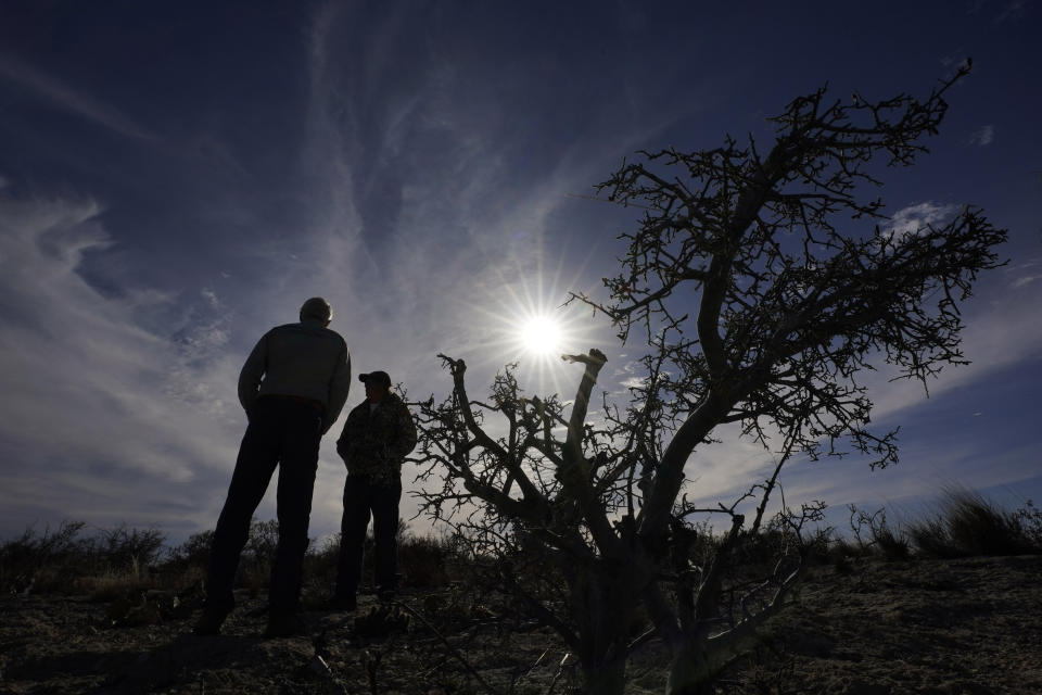 Rancher Randy Nunns, left, and Monarch Ranch manager Doug Meyer, right, overlook a bat cave on the property near Del Rio, Texas, Thursday, Feb. 16, 2023. Nunns and fellow landowners along the Devil's River argue that proposed wind turbines would kill birds, bats and disrupt monarch butterflies migrating to Mexico and impact ecotourism, a main source of income for many. (AP Photo/Eric Gay)