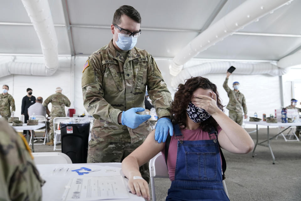 Leanne Montenegro, 21, covers her eyes as she doesn't like the sight of needles, while she receives the Pfizer COVID-19 vaccine at a FEMA vaccination center at Miami Dade College in Miami on April 5, 2021. (Lynne Sladky/AP)