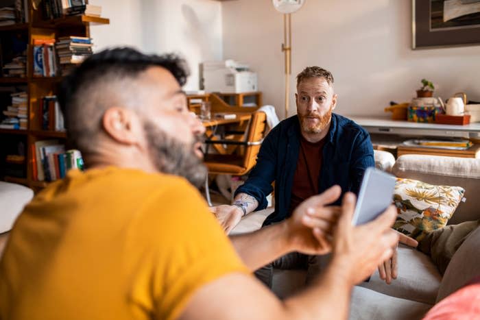 a guy showing another guy something on his phone