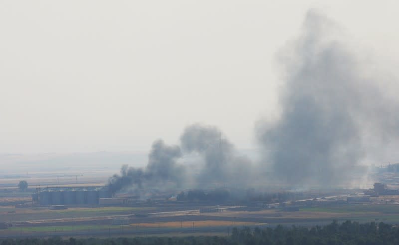 Smoke rises from a building near the Syrian town of Ras al-Ain as seen from the Turkish border town of Ceylanpinar