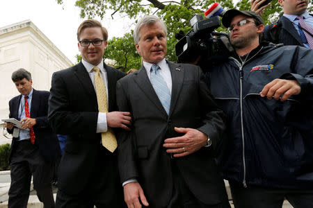 Former Virginia Governor Bob McDonnell (C) is trailed by reporters as he departs after his appeal of his 2014 corruption conviction was heard at the U.S. Supreme Court in Washington, U.S. April 27, 2016. REUTERS/Jonathan Ernst