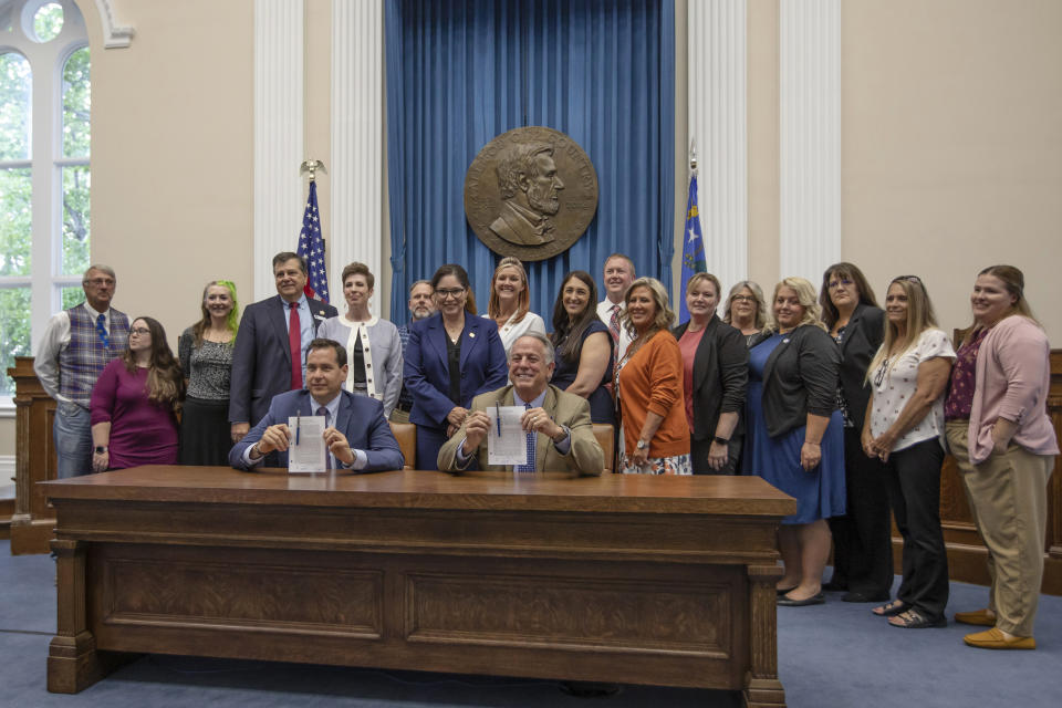 Nevada Governor Joe Lombardo, right, smiles with Nevada Secretary of State Cisco Aguilar after signing an election worker protection bill into law at the old Assembly Chambers in Carson City, Nev., Tuesday, May 30, 2023. (AP Photo/Tom R. Smedes)