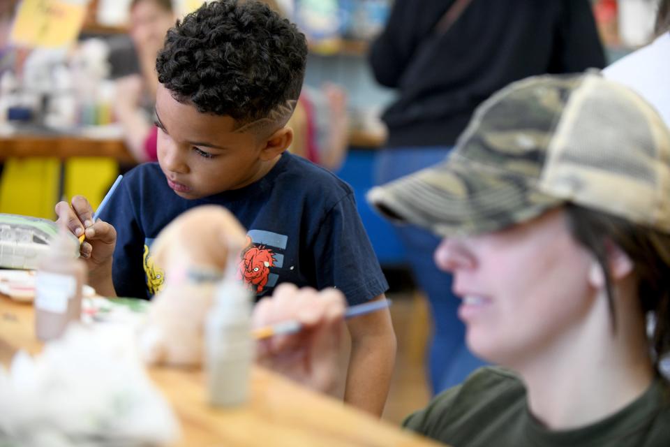 Art lover Jayden Richardson, 6, of Canton is hard at work Saturday, April 13, 2024, during a visit to Glazed and Amused pottery painting in North Canton with his mother, Macy Byrd, shown in foreground.