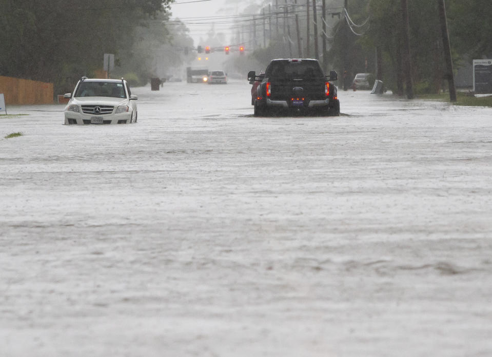 Cars sit stalled on a flooded Sale Road during heavy rains in Lake Charles, La., Monday, May 17, 2021. (Rick Hickman/American Press via AP)