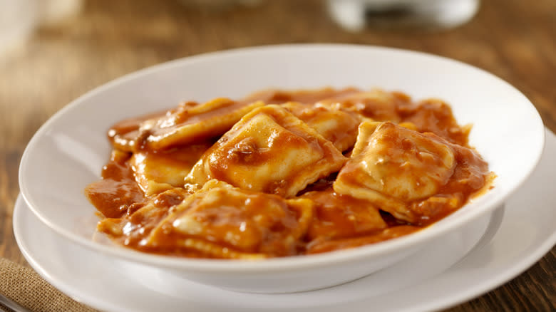 White bowl of ravioli in red sauce