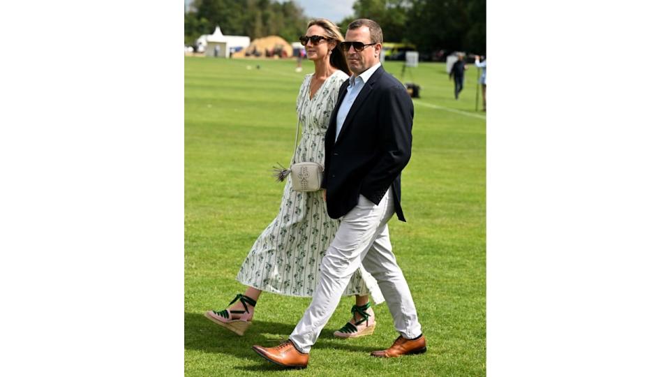 Harriet Sperling and Peter Phillips walk across polo field