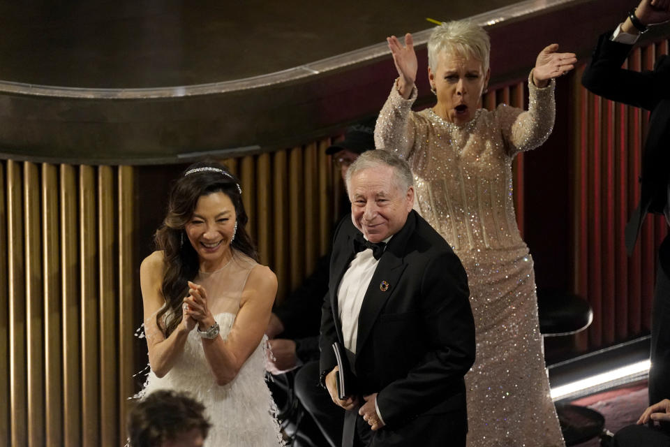 Michelle Yeoh, from left, Jean Todt, and Jamie Lee Curtis cheer in the audience at the Oscars on Sunday, March 12, 2023, at the Dolby Theatre in Los Angeles. (AP Photo/Chris Pizzello)