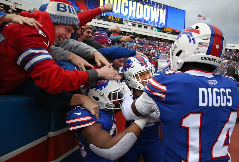 Buffalo wide receiver Gabe Davis (13), center, is mobbed by teammates and fans as they celebrate his 98-yard touchdown reception for his first touchdown in the first half during their game Sunday, Oct. 9, 2022 at Highmark Stadium in Orchard Park. 