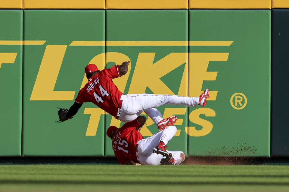 Cincinnati Reds' Aristides Aquino (44) catches a ball hit by San Francisco Giants' Tommy La Stella as he collides with teammate Nick Senzel (15) during the seventh inning of a baseball game in Cincinnati, Saturday, May 28, 2022. (AP Photo/Aaron Doster)