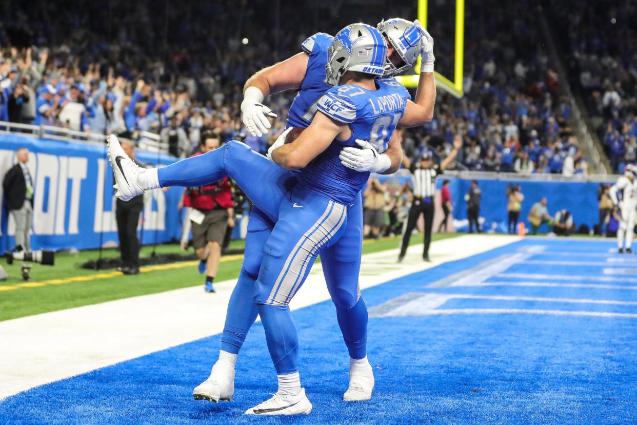 Detroit Lions tight end Sam LaPorta (87) celebrates a touchdown against the Denver Broncos with offensive tackle Dan Skipper (70) during the second half at Ford Field in Detroit on Saturday, Dec. 16, 2023.