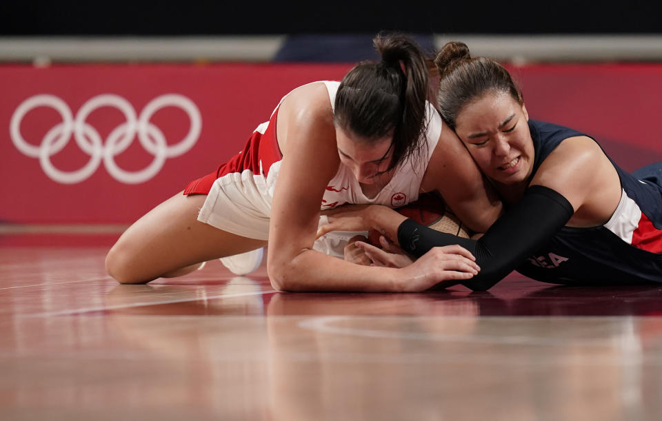 Canada's Bridget Carleton (6), left, and South Korea's Ji Su Park (19) fight for the loose ball during women's basketball preliminary round game at the 2020 Summer Olympics, Thursday, July 29, 2021, in Saitama, Japan. (AP Photo/Charlie Neibergall)