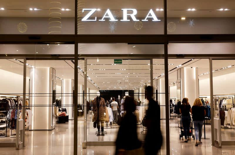FILE PHOTO: Shoppers walk past a Zara clothes store, part of the Spanish group Inditex