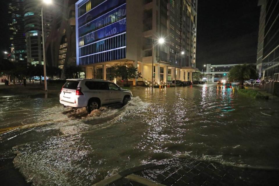 A car drives through a flooded NE 11 Street and Biscayne Boulevard in downtown Miami on Tuesday, February 16, 2021.