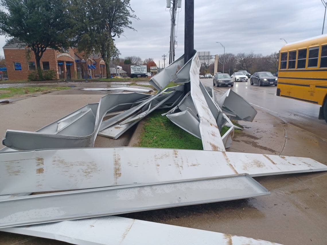Twisted metal from a building is caught on a power pole on Ira Woods Avenue in Grapevine after a storm Tuesday, Dec. 13, 2022.