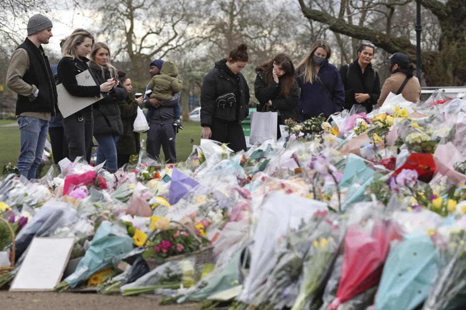 People gather to view and read inscriptions on floral tributes for murdered Sarah Everard, at the bandstand in Clapham Common, London