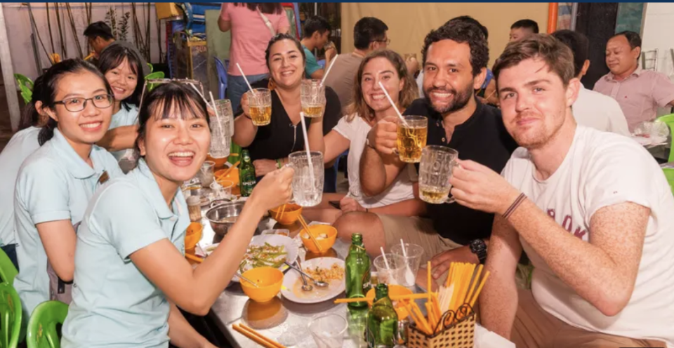 A group of friends holding up their drinks in an eatery.