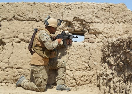A member of Afghan security force takes position during a battle with the Taliban in Kunduz province, Afghanistan