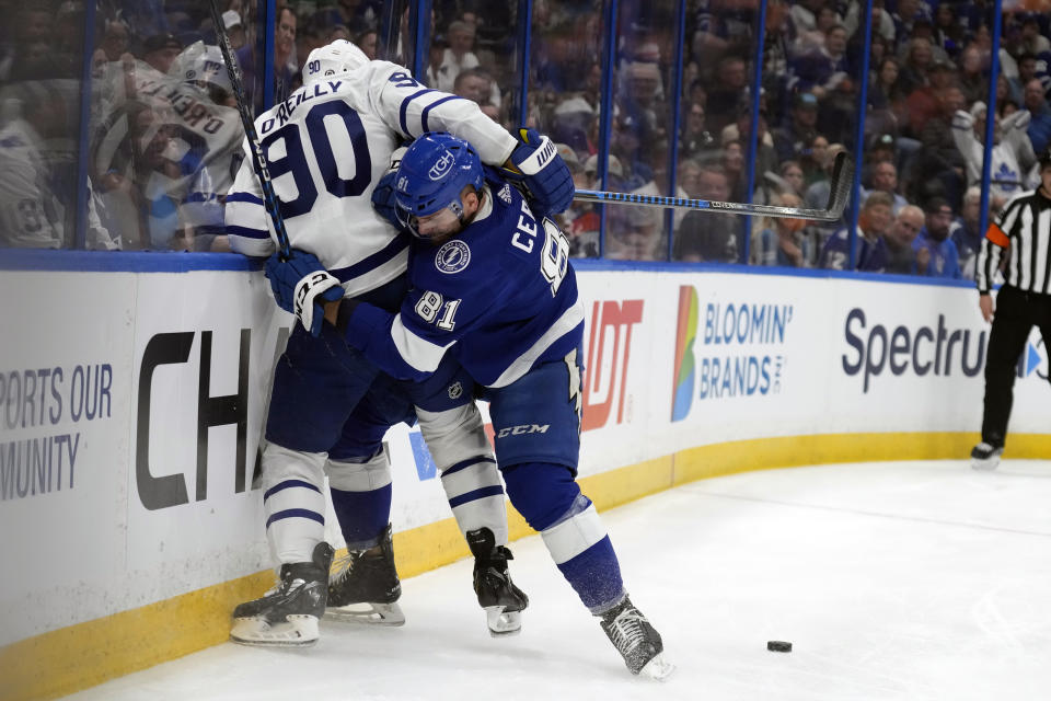 Tampa Bay Lightning defenseman Erik Cernak (81) pins Toronto Maple Leafs center Ryan O'Reilly (90) to the boards during the first period of an NHL hockey game Tuesday, April 11, 2023, in Tampa, Fla. (AP Photo/Chris O'Meara)