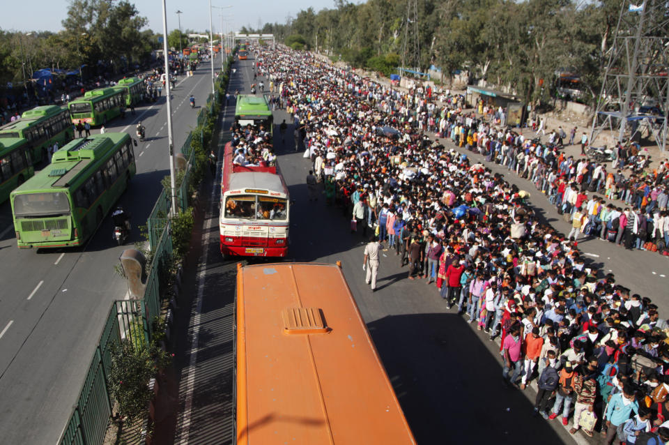 In this Saturday, March 28, 2020, file photo, Indian migrant laborers wait for buses provided by the government to transport them to their hometowns, following a lockdown amid concern over spread of coronavirus in New Delhi, India. Over the past week, India’s migrant workers - the mainstay of the country’s labor force - spilled out of big cities that have been shuttered due to the coronavirus and returned to their villages, sparking fears that the virus could spread to the countryside. It was an exodus unlike anything seen in India since the 1947 Partition, when British colothe subcontinent, with the 21-day lockdown leaving millions of migrants with no choice but to return to their home villages. (AP Photo, File)