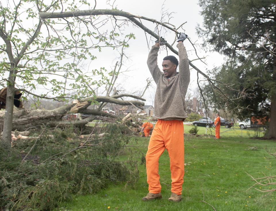 Portage County Jail inmate Nate Lewis helps clear debris Friday, April 19, 2024, from a fallen tree at Windham Cemetery as part of the Inmate Training Program in which nonviolent jail inmates are tasked with work in communities around Portage County. A tornado touched won Wednesday, April 17, 2024, in Windham.