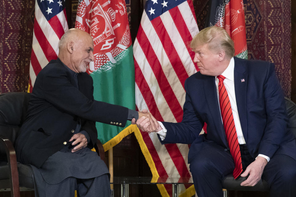 FILE - In this Thursday, Nov. 28, 2019 file photo, President Donald Trump shakes hands during a meeting with Afghan President Ashraf Ghani during a surprise Thanksgiving Day visit, at Bagram Air Field, Afghanistan. A new survey released by the Asia Foundation Tuesday, Dec. 3, 2019, says Afghans are increasingly fearful for their personal safety, but slightly more believe their war-weary country is moving in the right direction compared to previous years. (AP Photo/Alex Brandon, File)