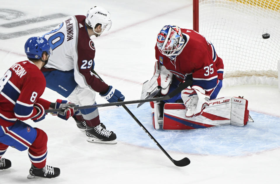 Colorado Avalanche's Nathan MacKinnon (29) scores against Montreal Canadiens goaltender Sam Montembeault as Canadiens' Mike Matheson defends during third-period NHL hockey game action in Montreal, Monday, March 13, 2023. (Graham Hughes/The Canadian Press via AP)