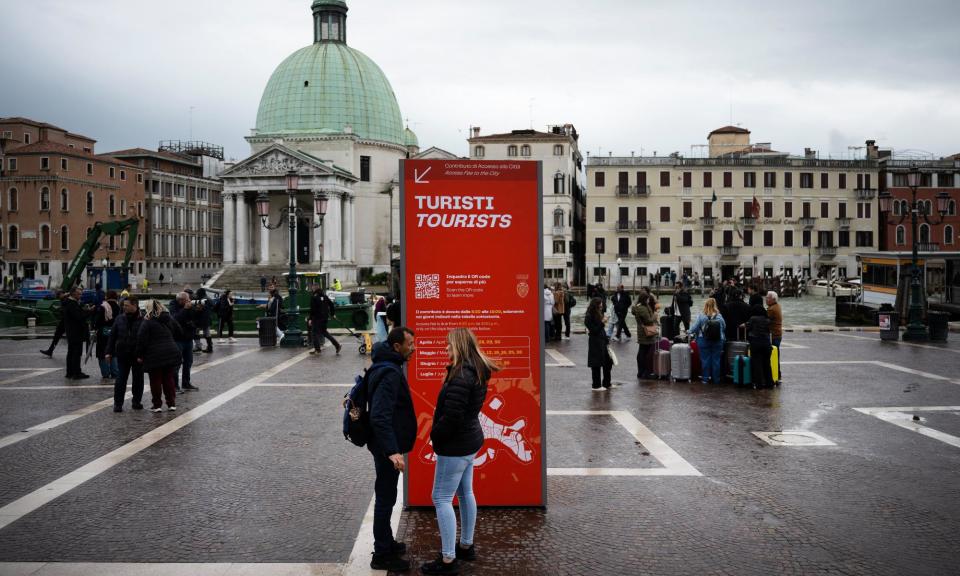 <span>A board near Santa Lucia train station giving information about Venice's entry charge.</span><span>Photograph: Marco Bertorello/AFP/Getty Images</span>