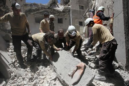 Civil defense members search for survivors under the rubble at a site hit by airstrikes in the rebel-controlled town of Ariha in Idlib province, Syria. REUTERS/Ammar Abdullah