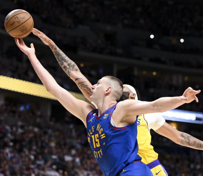 DENVER, CO - MAY 16: Denver Nuggets center Nikola Jokic, front, shoots while pressured by Los Angeles Lakers forward Anthony Davis during the first half of game one in the NBA Playoffs Western Conference Finals at Ball Arena on Tuesday, May 16, 2023 in Denver, CO. (Wally Skalij / Los Angeles Times)