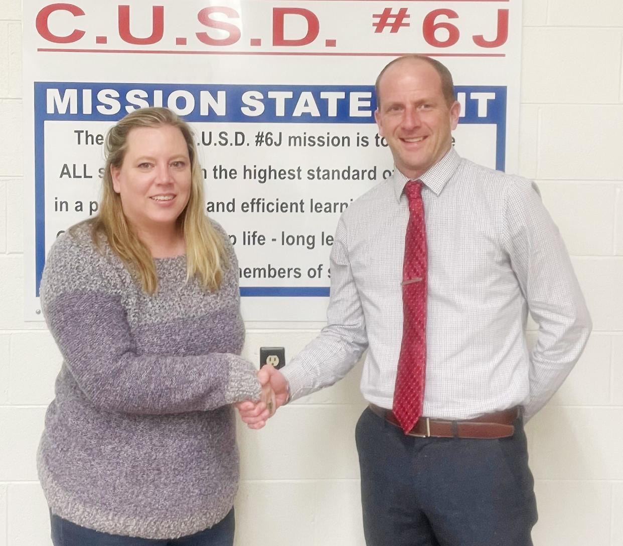 Tri-Point Upper Elementary/Junior High School Principal Jay Bennett was hired as superintendent of the Tri-Point school district effective July 1. He is congratulated here by Tri-Point School Board President Cherie Smolkovich.