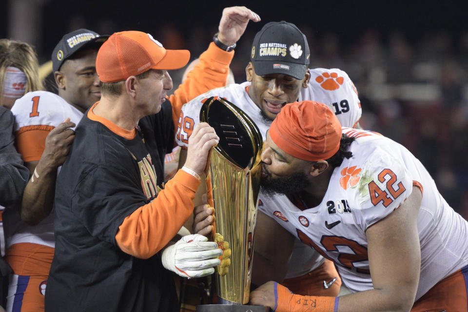 Clemson head coach Dabo Swinney, defensive tackle Christian Wilkins (42) and defensive end Clelin Ferrell (99) celebrate with the championship trophy. (Photo by Douglas Stringer/Icon Sportswire via Getty Images)
