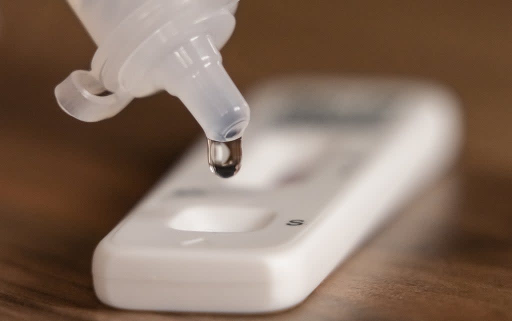 A person dripping testing solution into a Covid 19 lateral flow testing strip (Danny Lawson/PA) (PA Wire)