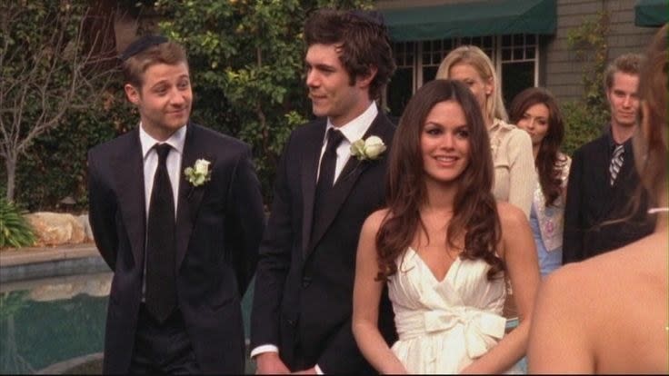 Summer, in a white gown, stands next to Seth and Ryan, both in black suits with white boutonnieres
