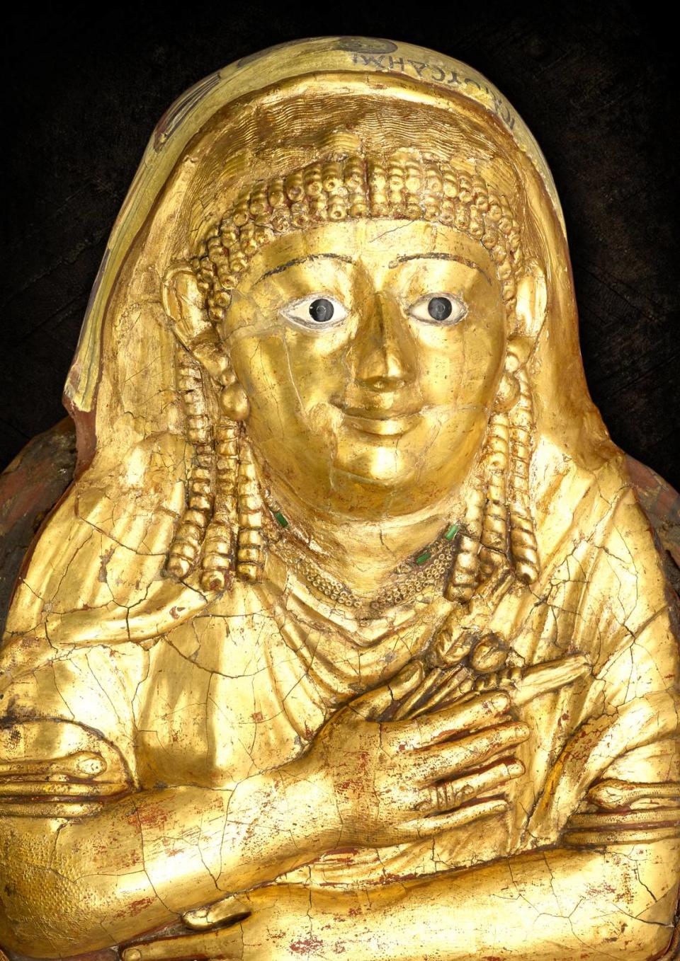 Egyptian, from Hawara, Mummy of a woman called Isaious (detail), 1st century C.E., human remains, linen, plaster, and gold leaf, Manchester Museum. The gilded mask of this mummy shows the deceased with a Roman hairstyle and jewelry.