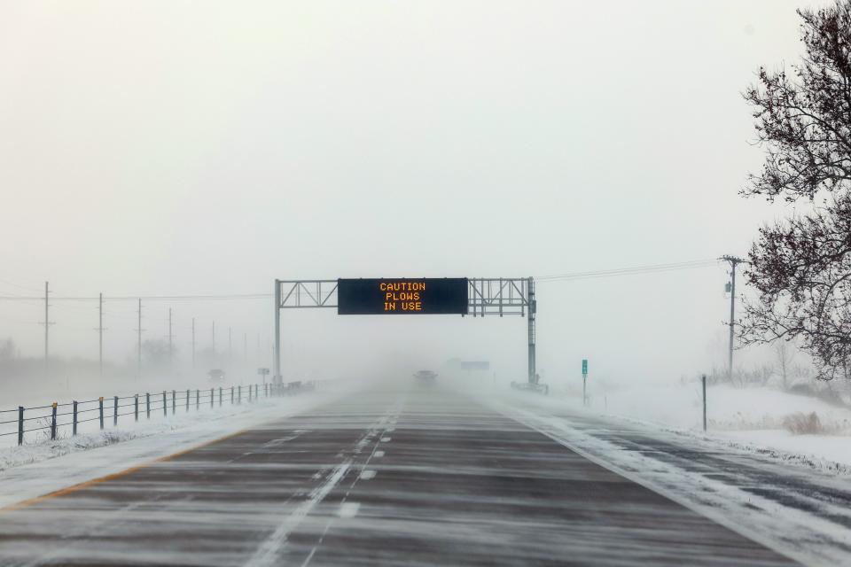 A sign on I-35 advises motorist of snow plow use as strong winds blow snow over the road on Jan. 13, 2024, in Council Bluffs, Iowa. The second winter weather system in a week is bringing blizzard conditions across Iowa as caucusgoers prepare for the Republican presidential caucuses on Jan. 15.