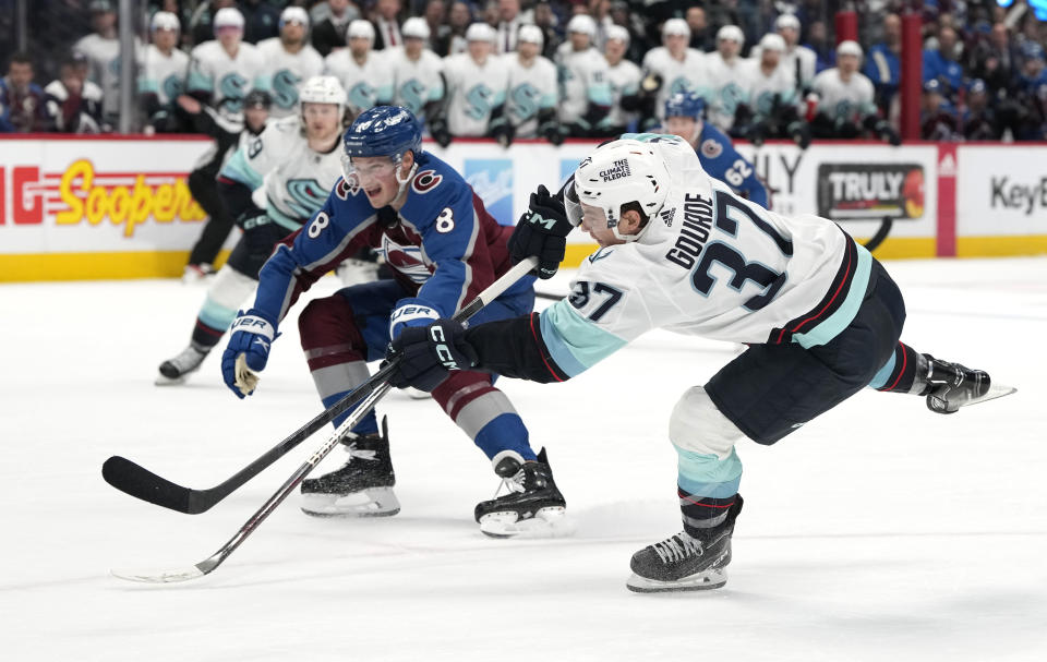 Seattle Kraken center Yanni Gourde, front, scores the winning goal as Colorado Avalanche defenseman Cale Makar covers in overtime of an NHL hockey game, Sunday, March 5, 2023, in Denver. (AP Photo/David Zalubowski)