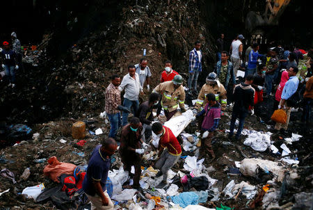 Rescue workers carry the body of a victim recovered out from a pile of garbage following a landslide when a mound of trash collapsed on an informal settlement at the Koshe garbage dump in Ethiopia's capital Addis Ababa, March 13, 2017. REUTERS/Tiksa Negeri