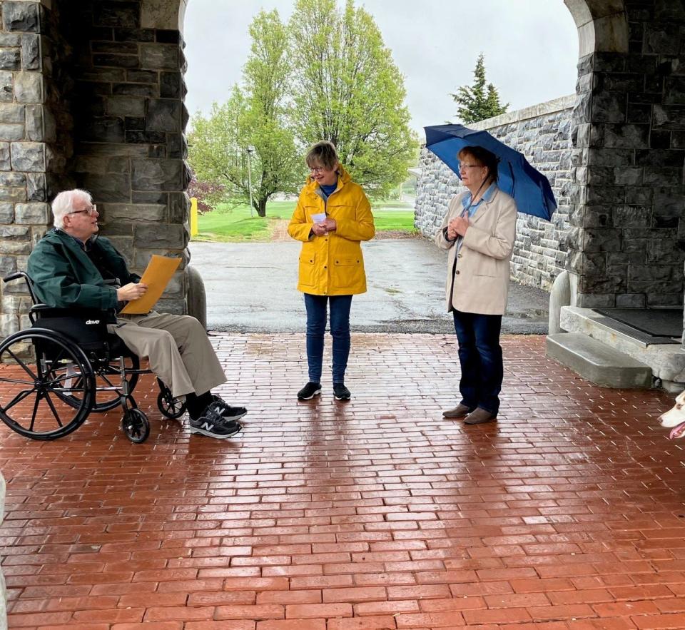 Alliance Mayor Alan Andreani reads a proclamation in honor of Arbor Day as Christy Ballor, wife of honoree Jim Ballor, and Pat Stone from the Alliance Shade Tree Commission look on Friday, April 28, 2023, at Glamorgan Castle. Because of the rainy weather, the event was held under the castle's portico.