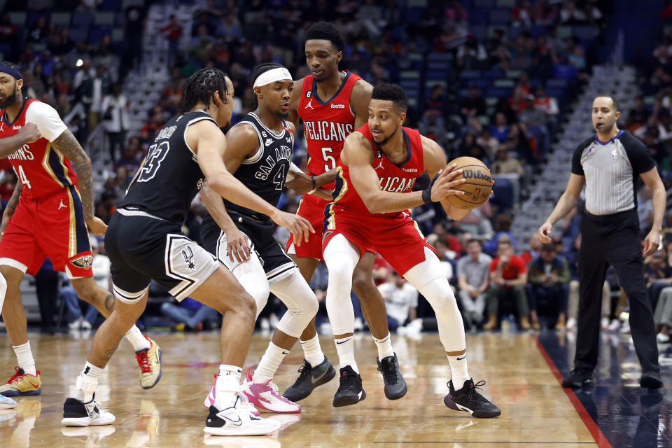New Orleans Pelicans guard CJ McCollum (3) is defended by San Antonio Spurs guards Tre Jones (33) and Devonte' Graham (4) in the first half of an NBA basketball game in New Orleans, Tuesday, March 21, 2023. (AP Photo/Tyler Kaufman)