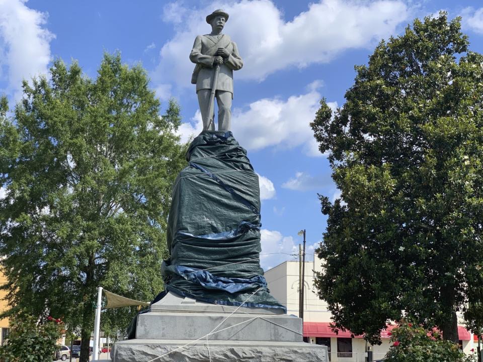 The base of a Confederate statue in Tuskegee, Ala., is covered with a tarp.