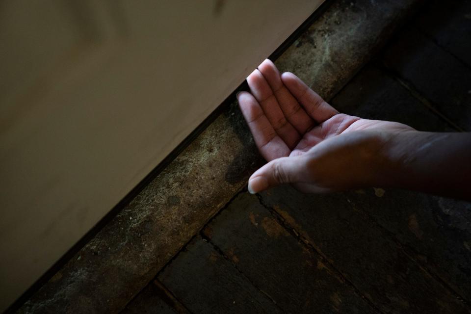 Arica Crowder, 26, shows how exterior doors don't fit properly allowing cold air in at the Detroit apartment she rents on Oct. 18, 2022. (Photo: Mandi Wright, Detroit Free Press)