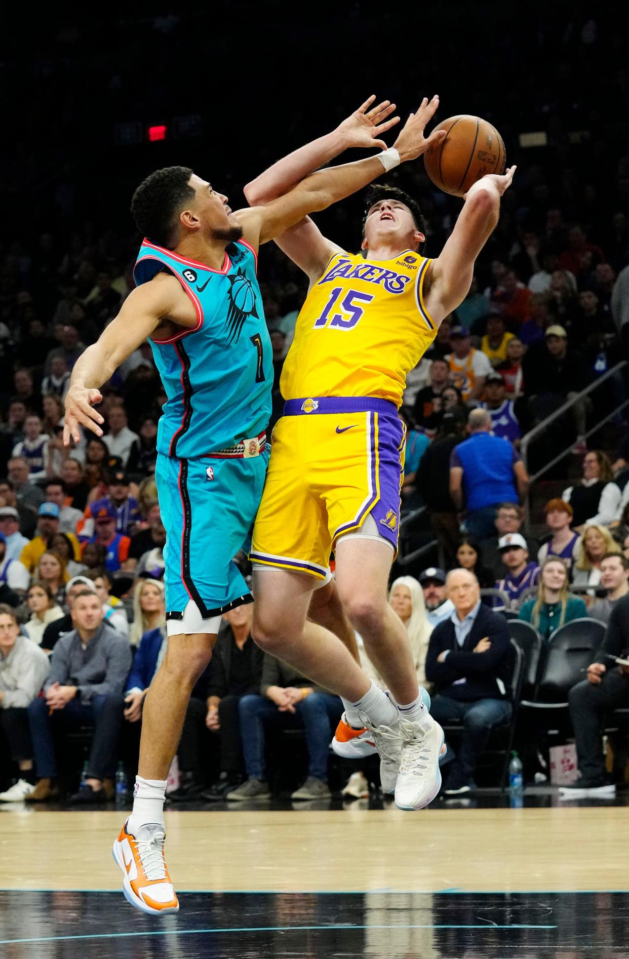 Phoenix Suns guard Devin Booker (1) fouls Los Angeles Lakers guard Austin Reaves (15) in the second half at Footprint Center on Nov. 22, 2022.