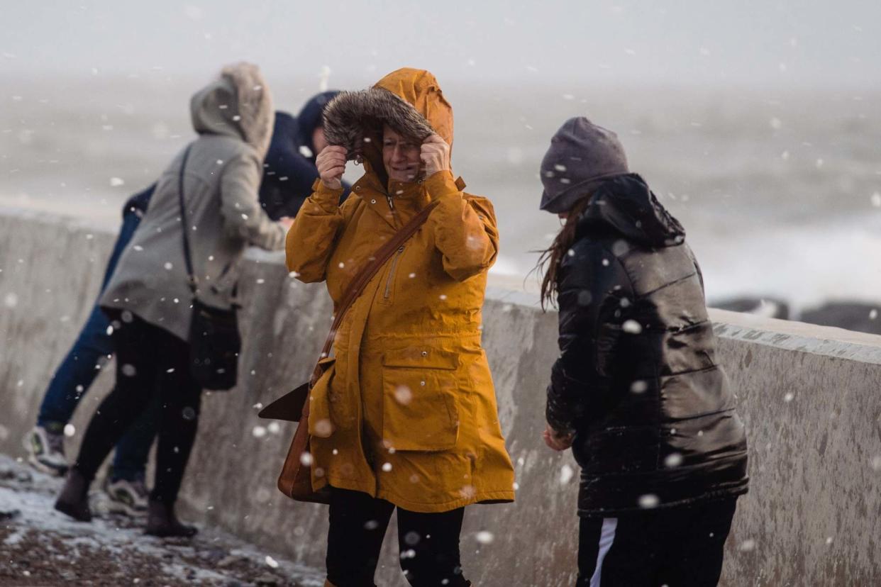 People walk through flying sea foam spray in Porthcawl: Getty Images